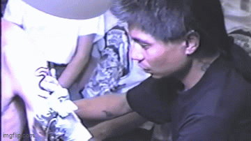 gif de Leo Zulueta tatuando um dragão neotribal preto em uma convenção