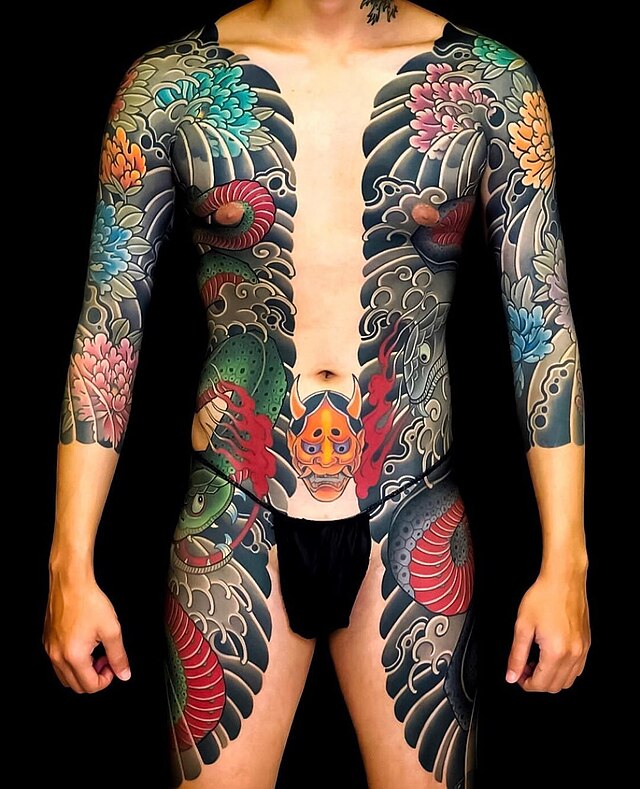 Body suit de tatuagem japonesa tradicional Irezumi com demônio Hannya, peixes Koi e flores, refletindo a arte da tatuagem ancestral.